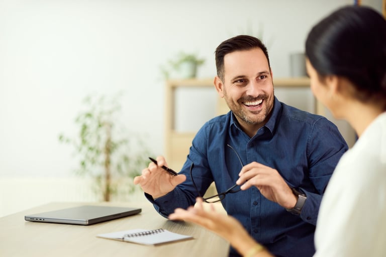 Friendly conversation between colleagues discussing ideas in a bright modern office
